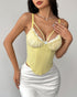 Woman in yellow corset top with ruffled cups and white lace trim paired with white satin skirt.