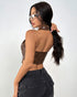 Back view of woman in brown PU halter corset with open back and dark jeans.