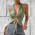 Woman in sage green halter PU corset top with lace-up front and denim jeans.