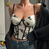 Woman styles cream floral corset with black shirt draped off shoulders.