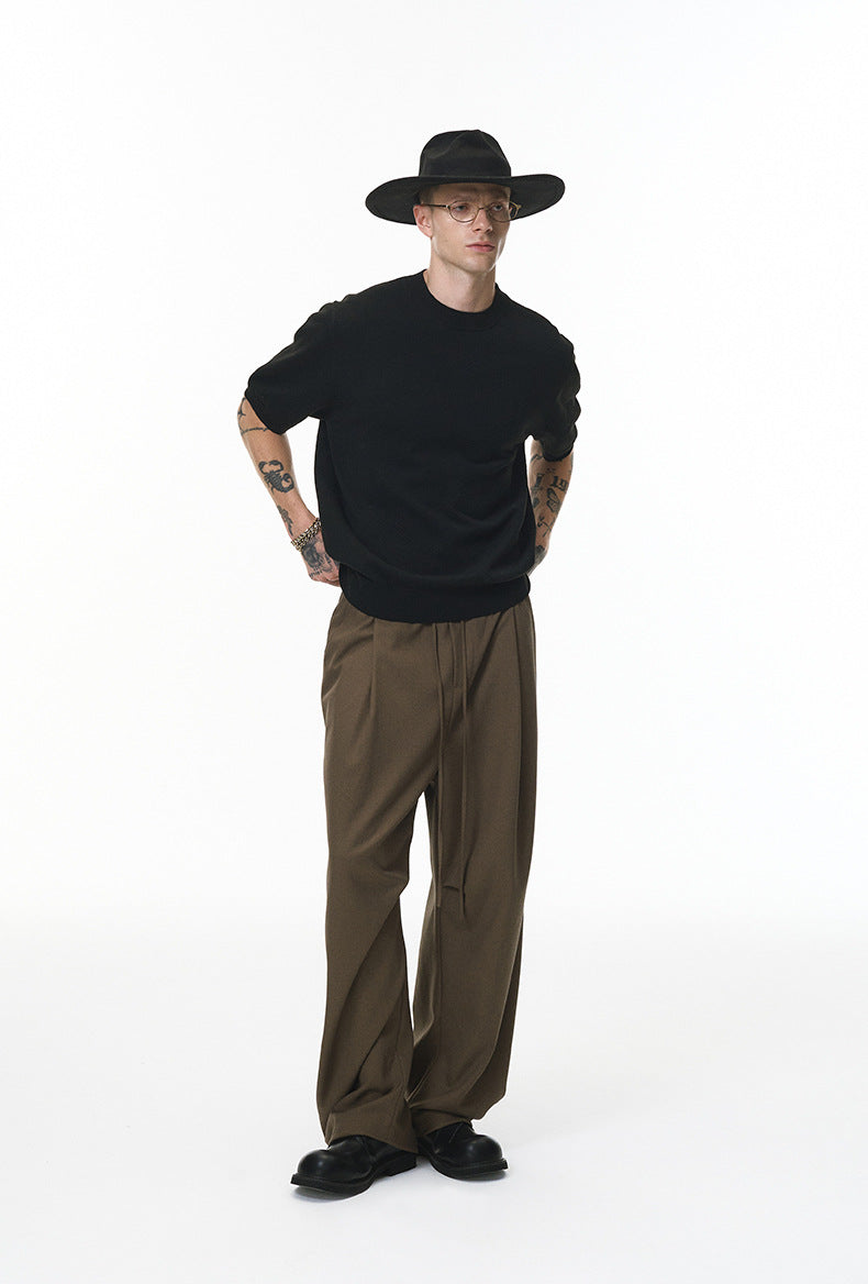 Black short sleeve knit top styled with hat and brown trousers