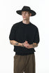 Black short sleeve knit top side view styled with brown pants
