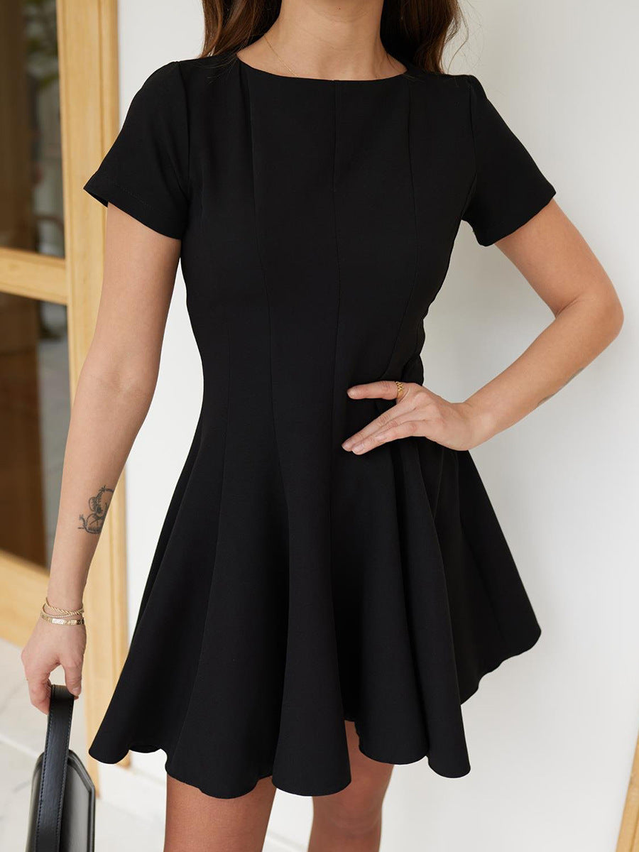 Close-up of fitted bodice and flared skirt of black short sleeve mini dress.