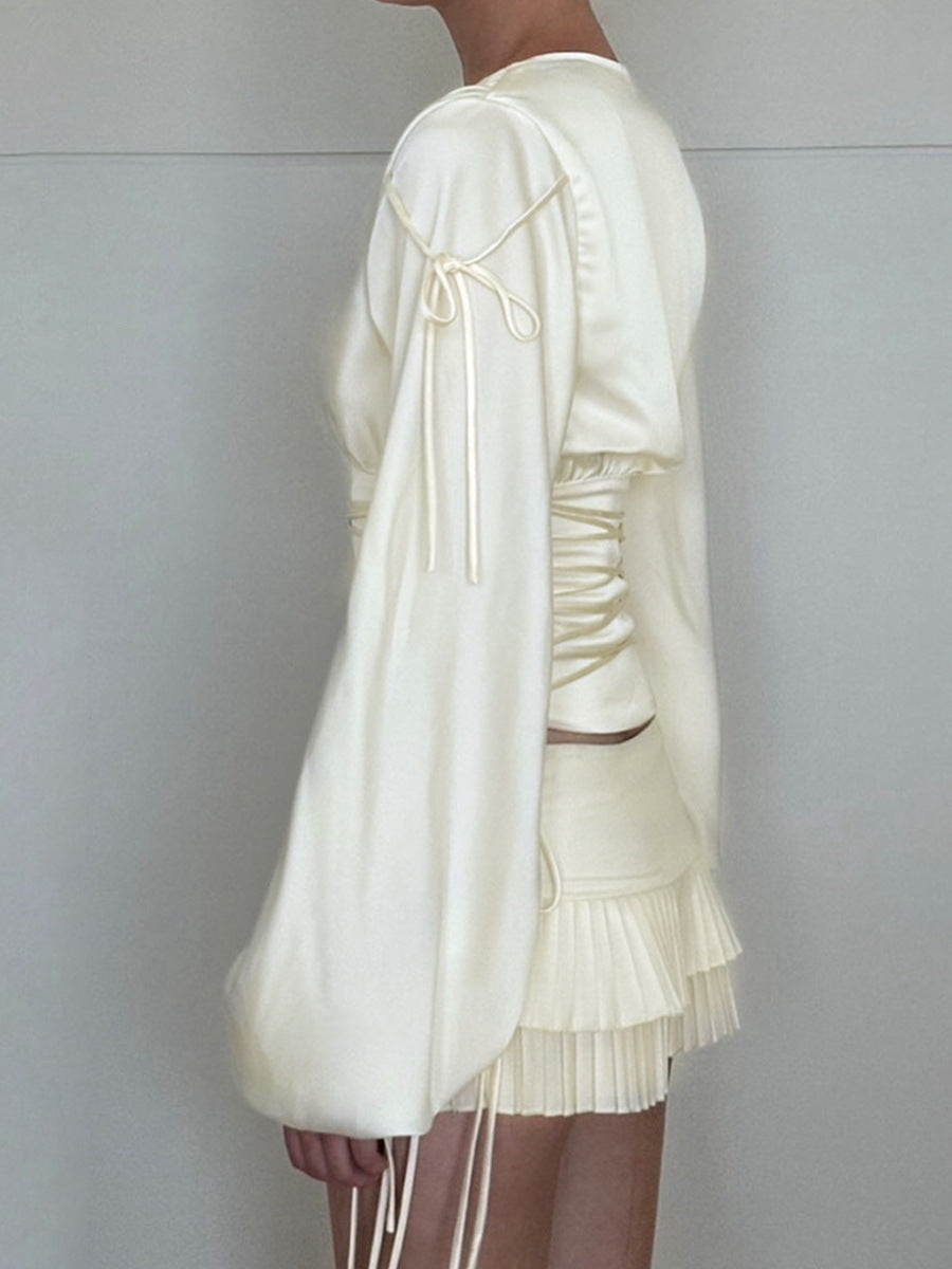 Side view of white satin ruched waist top with long sleeves