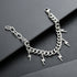 Silver Cuban chain bracelet with lightning bolt charms on black surface.