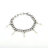 Silver bracelet with lightning charms laid out on white background.