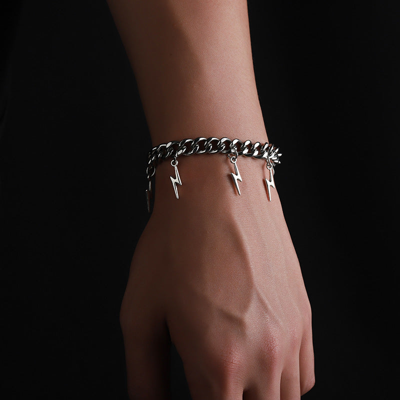 Hand wears silver bracelet with hanging lightning charms.