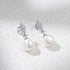  Silver-tone diamond-shaped stud pearl drop earrings.