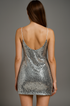 Back view of silver sequin dress worn by a model on a gray background