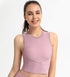 Woman modeling pink ribbed workout tank with contour seams and stretch fit.