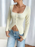 three-quarter view showing button front and waist-slimming pointed hem on rib knit crop top