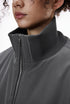 Close-up of a person wearing a gray bomber jacket with collar stand detail
