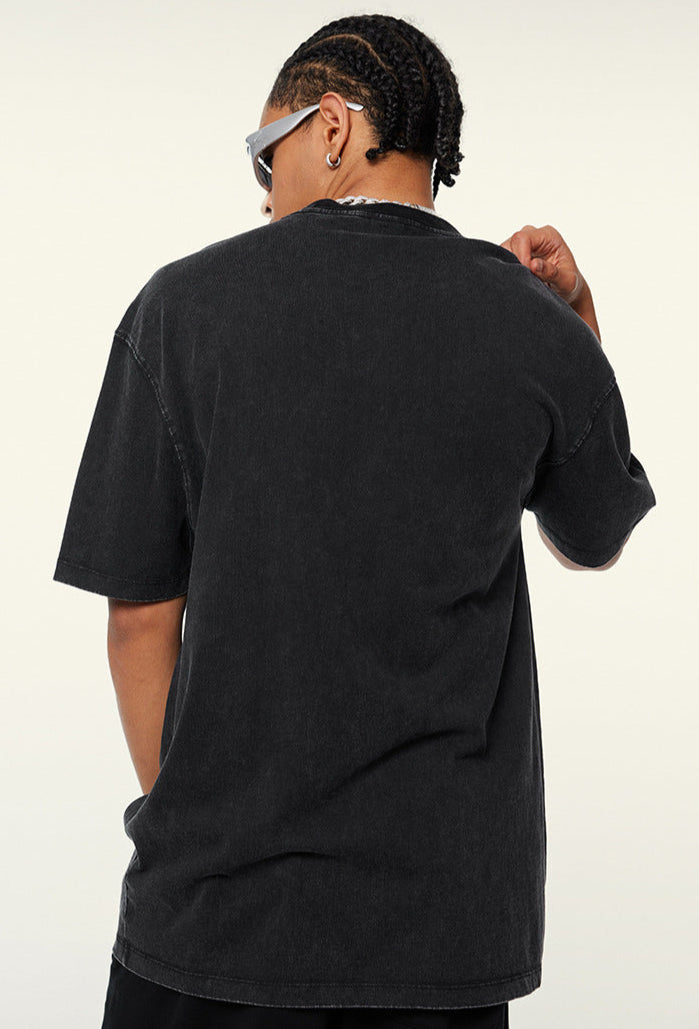 Back view of plain black oversized T-shirt worn by model.