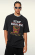 Model in black T-shirt with bullet fries design, posing with one hand hiding.