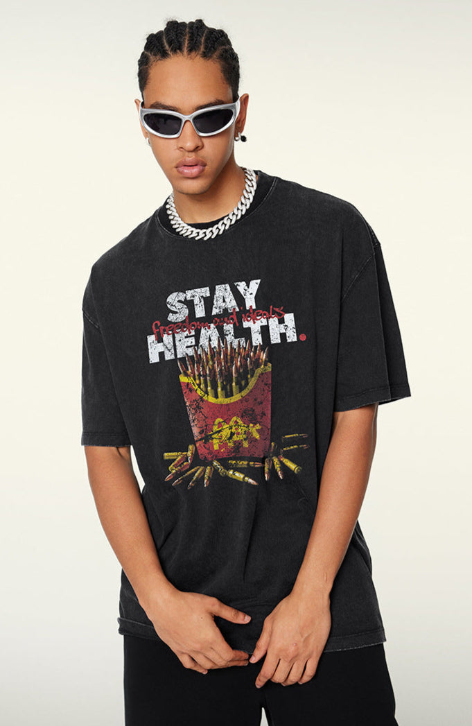 Model in black T-shirt with bullet fries design, posing with hands clasped