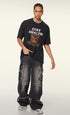 Model stands with one hand in pocket, wearing black T-shirt featuring satirical bullet fries design