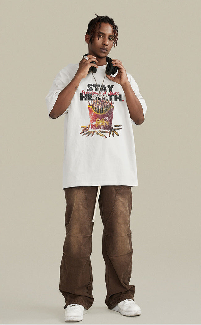 Model wearing white graphic T-shirt with bullet fries artwork and satirical text.