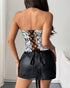 Back view of corset showing lace-up detail with black satin ribbons and a leather skirt.
