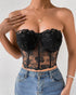 Close-up of black floral mesh corset top with rose embroidery and sheer detail.