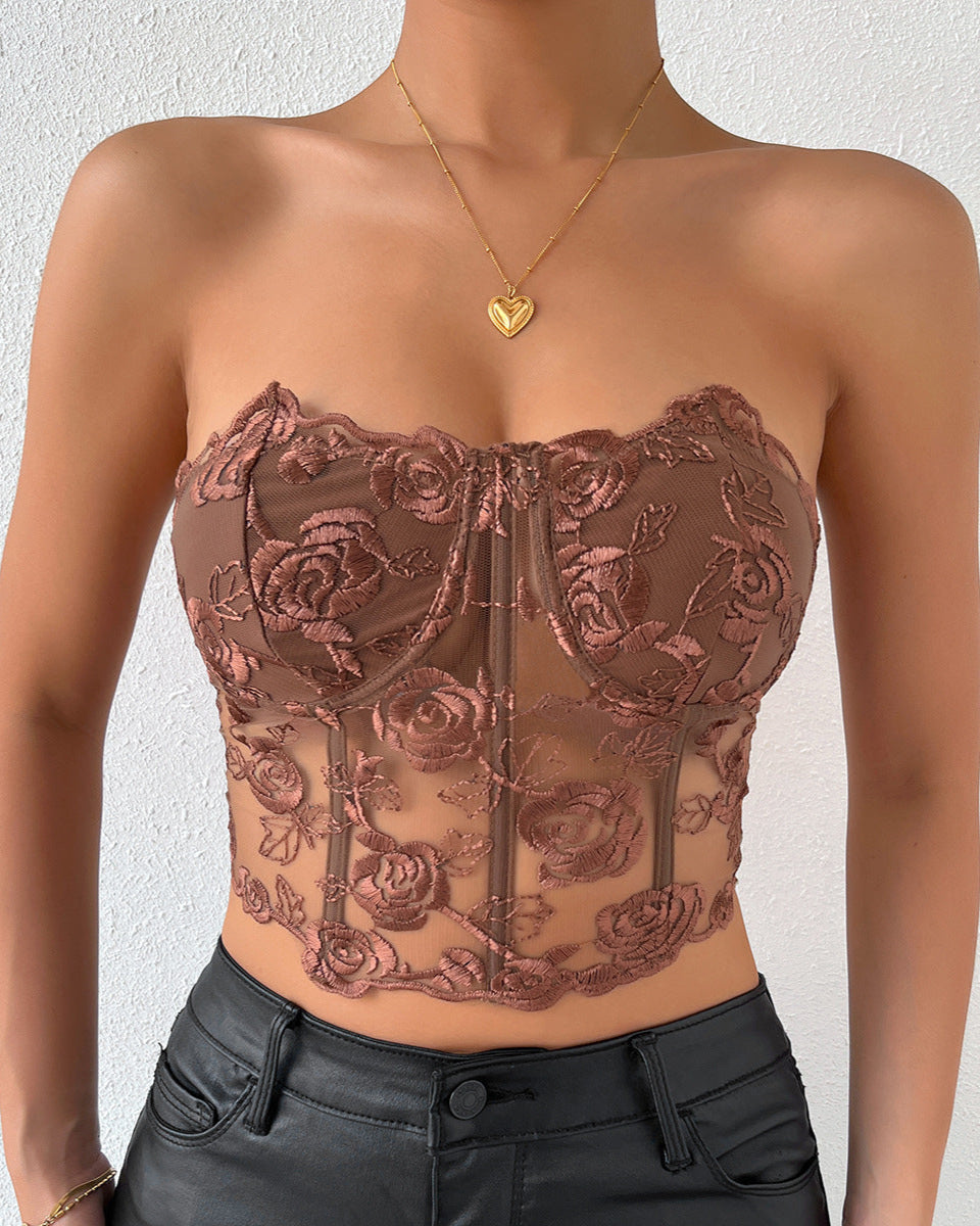 Model wears brown strapless corset with floral embroidery and sheer design.