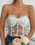 Model holds roses while wearing white floral mesh corset with sculpted cups.