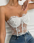 Side pose of woman in white lace mesh bustier styled with jeans.