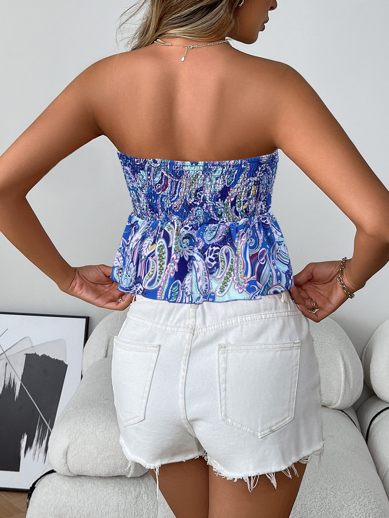 Back view of  blue smocked boho strapless tube top with flare hem in paisley print