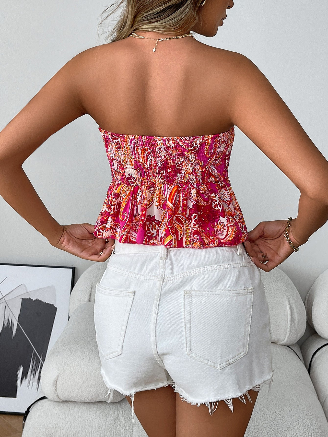Back view of cranberry smocked boho strapless tube top with flare hem in paisley print