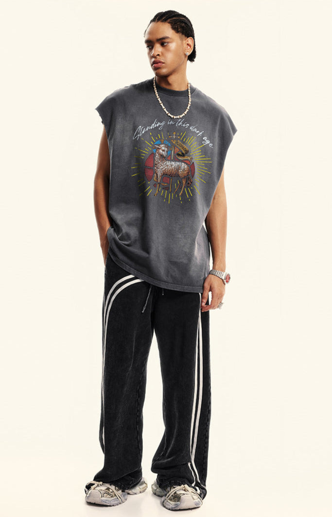 Model wears dark gray tribal ram tee with track pants and chunky sneakers