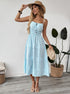 Model in striped cami midi dress holding straw hat and bag, styled for summer.