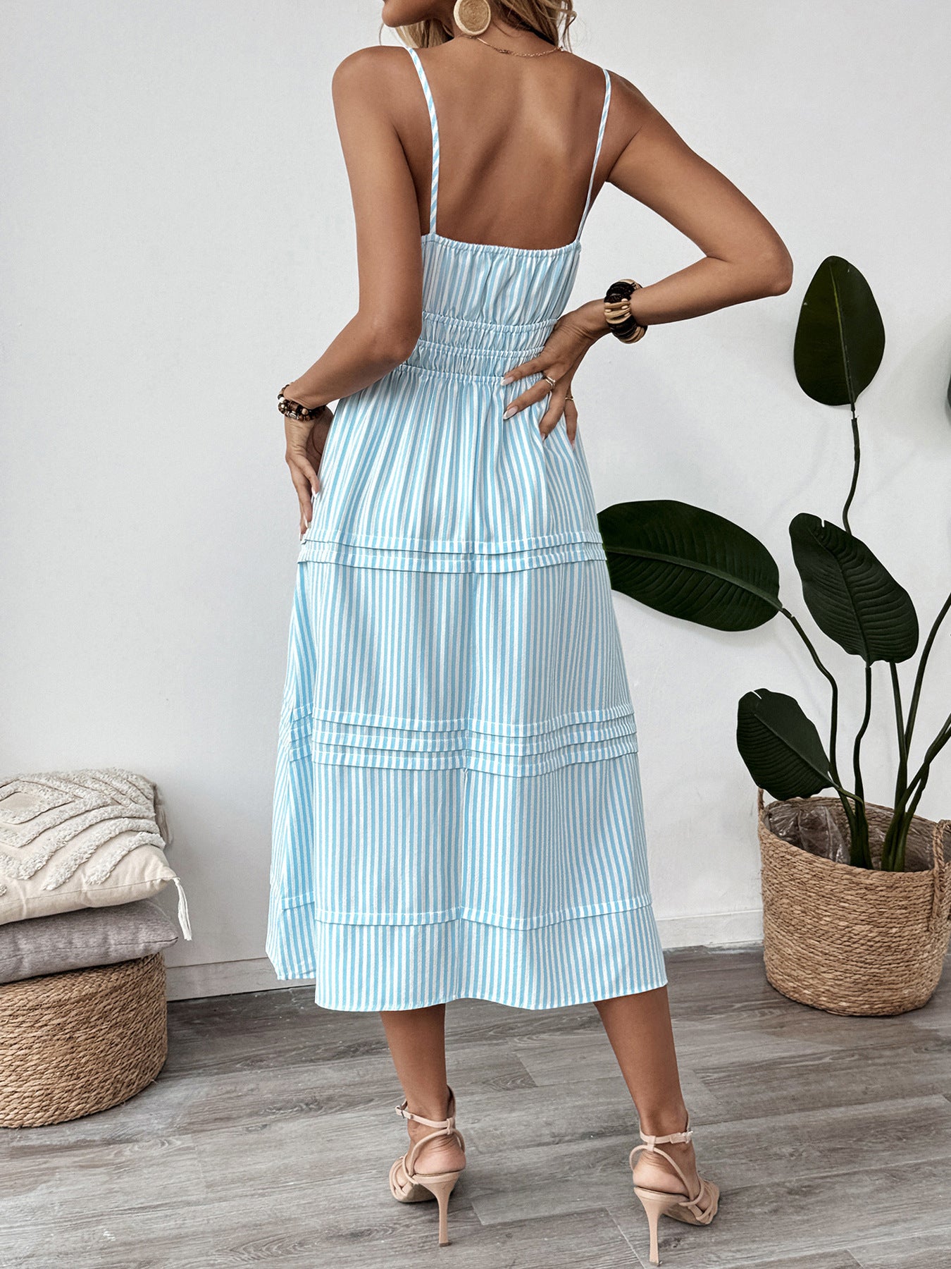 Back view of striped midi cami dress showing thin straps and smocked bodice.