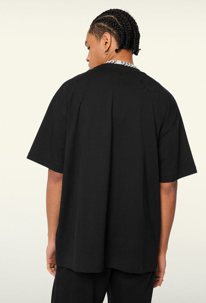 Angled back view of black oversized tee, plain with drop-shoulder fit.