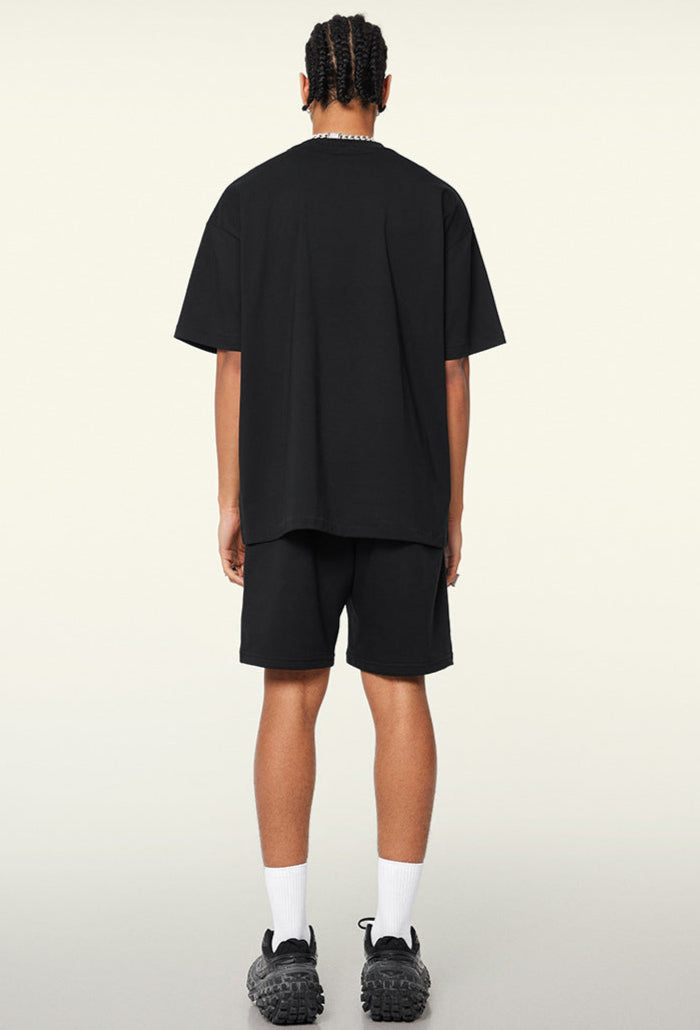 Model shows back of black oversized tee with no visible print.