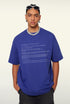 Angled pose of model wearing blue tee with system print and sunglasses.