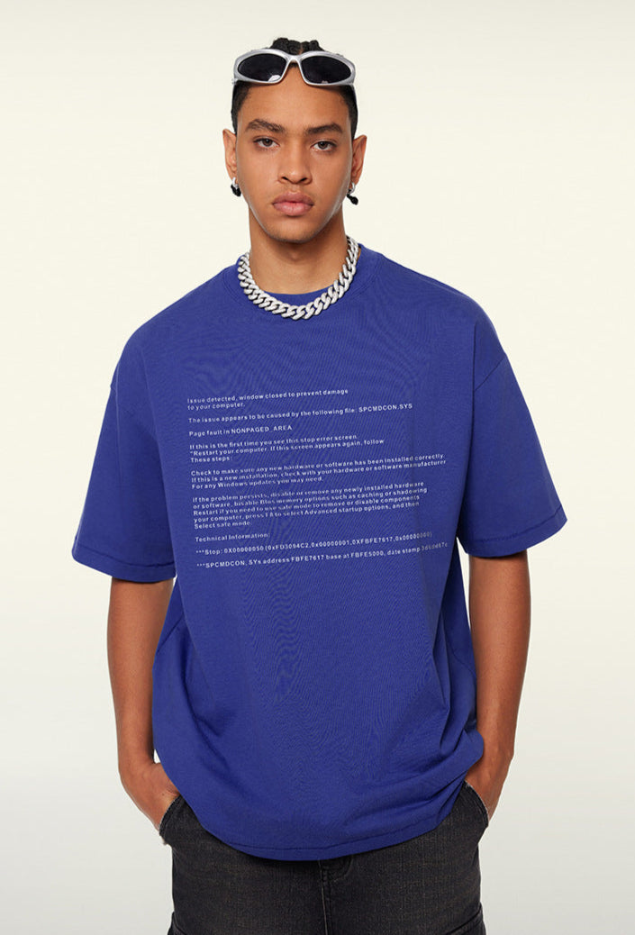 Angled pose of model wearing blue tee with system print and sunglasses.