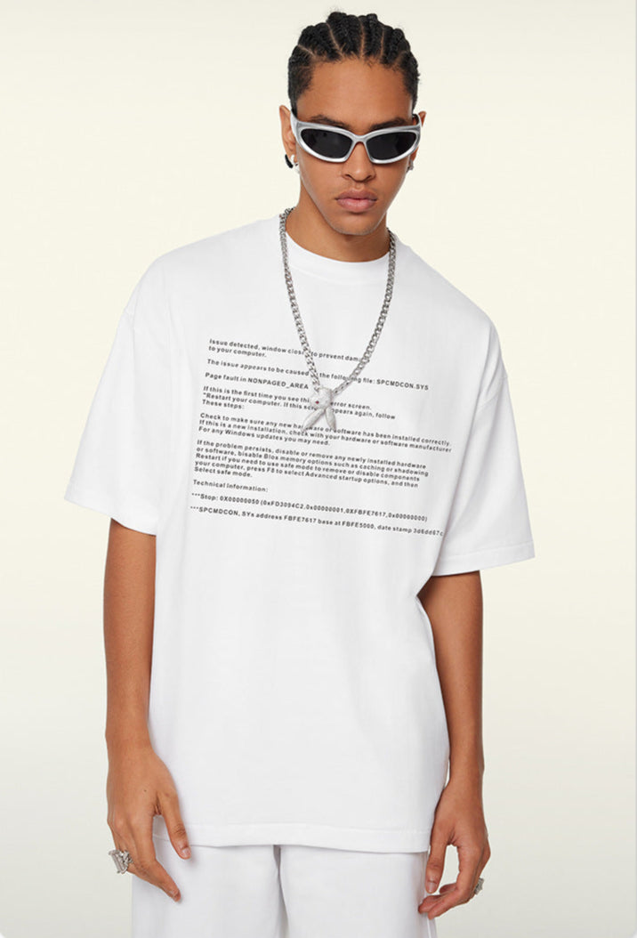 Model looks down wearing white system text tee and sunglasses.