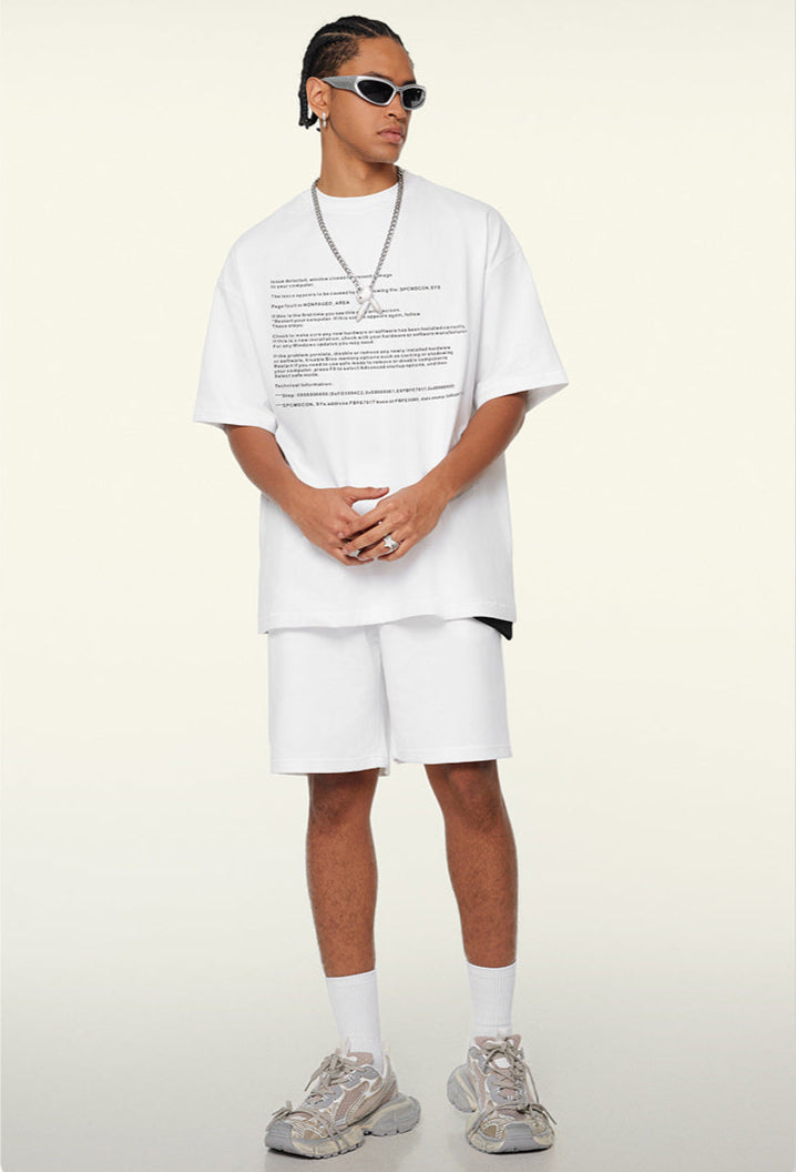 Model angles body in white tee with printed text and layered accessories.