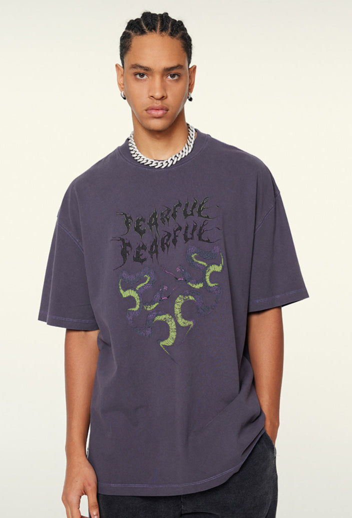 Close-up of purple "Terrible Beauty" tee and snake-heart design.