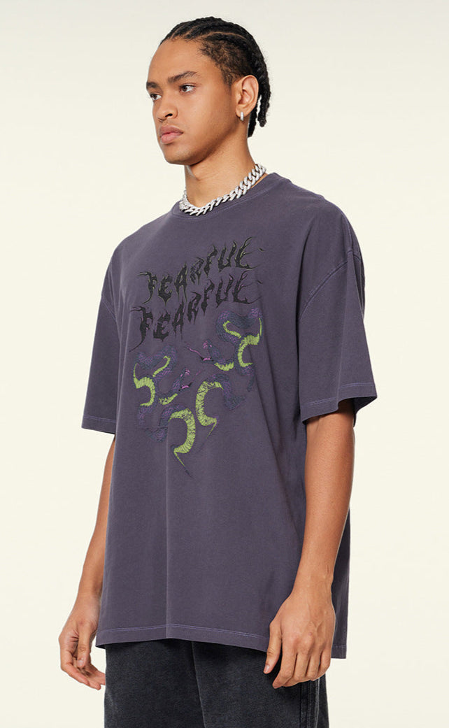Side view of purple "Terrible Beauty" tee with chain necklace.