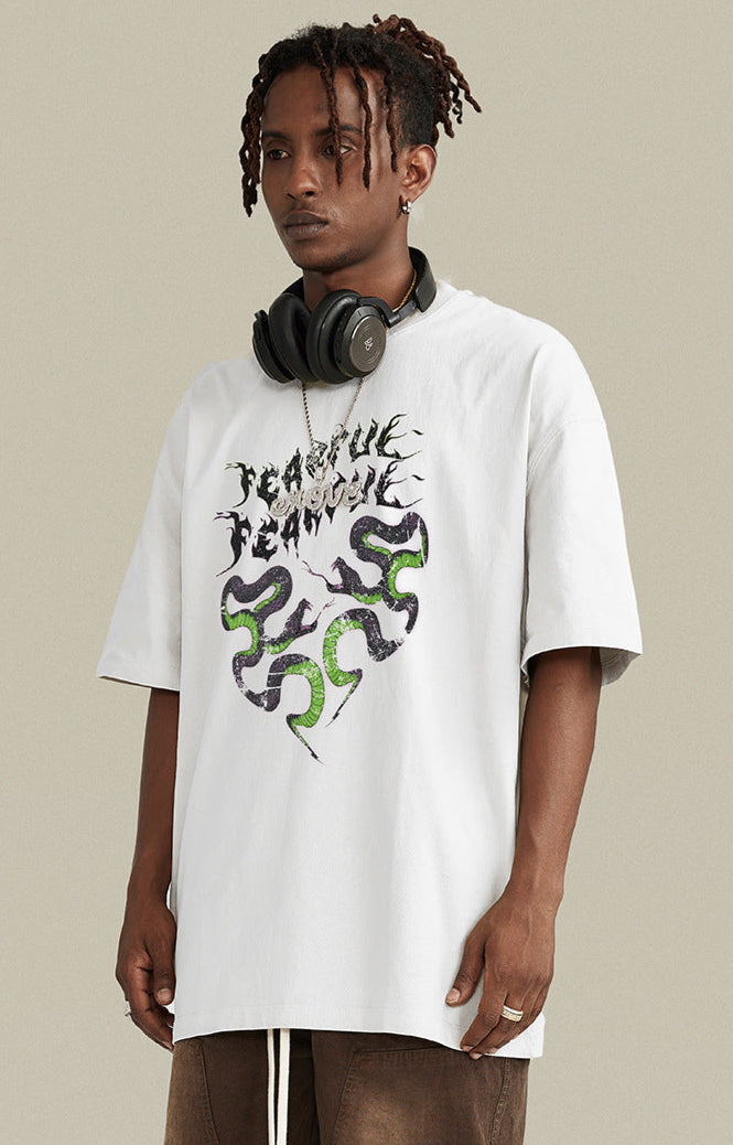 Model in white "Terrible Beauty" tee facing left with headphones around neck.