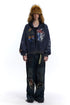 Navy oversized graffiti zip-up hoodie styled with distressed wide-leg jeans and a fur hat.