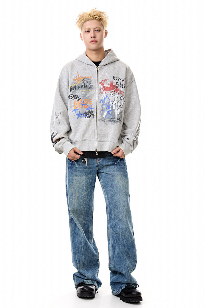 Heather gray oversized graffiti zip-up hoodie styled with wide-leg blue jeans.
