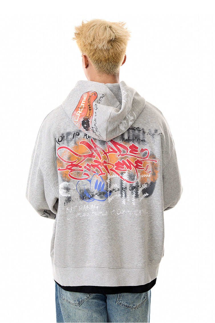 Back view of gray oversized hoodie showing large graffiti artwork across the hood and body.