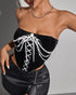 Black velvet corset with white lace-up front and pearl chains.