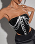 Side view of black bustier with layered pearls and satin ribbon.
