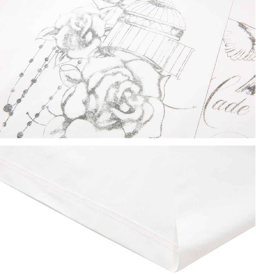 Close-up of the hand-drawn rose and birdcage print with a clean straight hem
