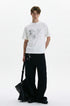 White hand-drawn graphic T-shirt styled with black wide-leg trousers