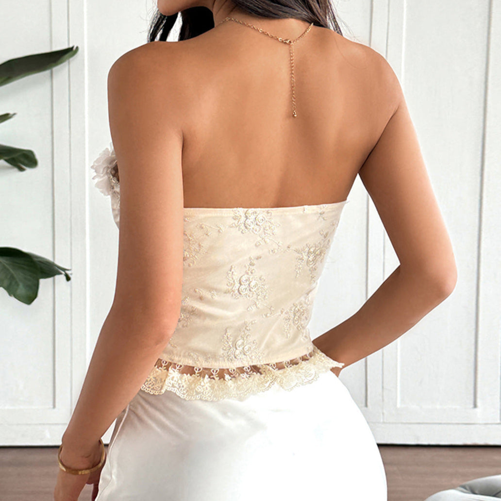 Back view of cream lace corset top with floral embroidery and ruffled hem.