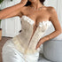 Woman in cream strapless corset top with floral appliqué and lace-up front.