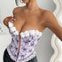 Close-up of lavender bustier with embroidered floral details and lace edging.